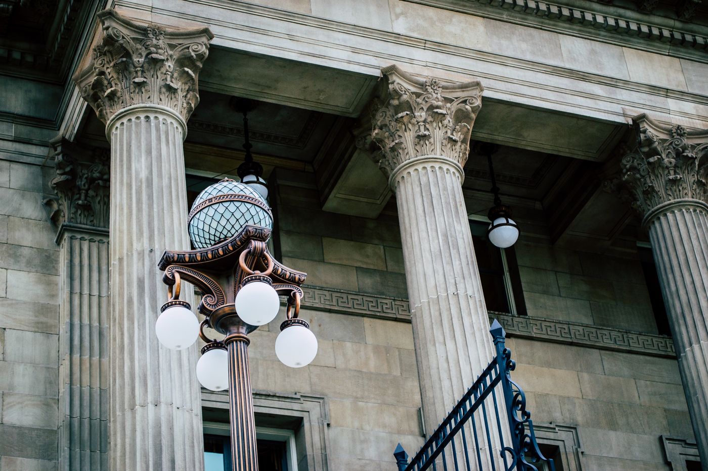 Carved stone columns and an ornate iron street lamp outside a historic courthouse